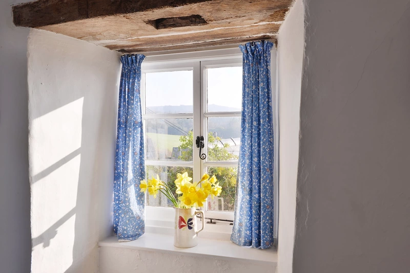 Country house window sill with daffodils in a vase