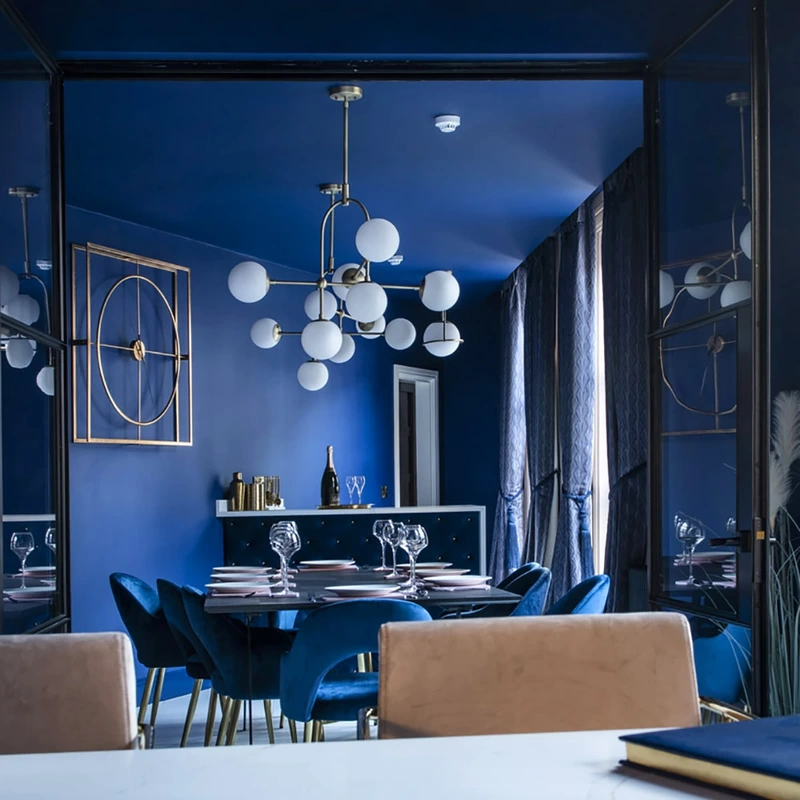 Interior shot of dining room with blue walls and blue upholstery