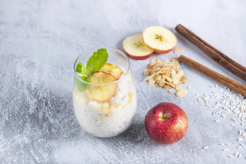 Rice pudding in a glass with fresh apple and cinnamon