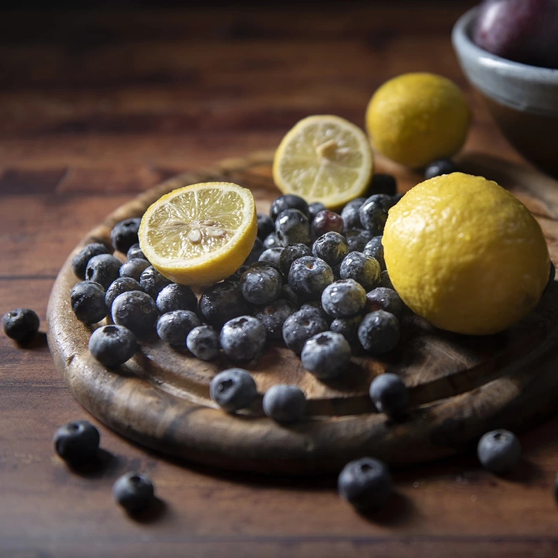 Fresh lemons and blueberries on a wooden baord