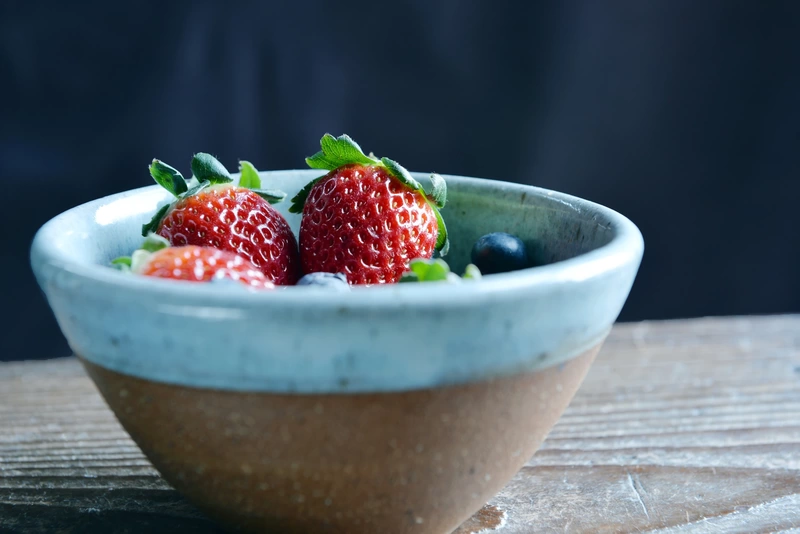 A detail shot of a bowl of fresh strawberries