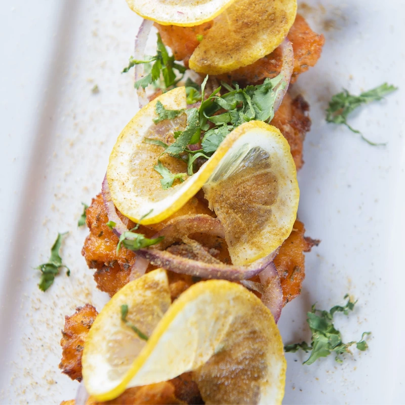 A detail shot of fish pieces with fresh lemon slices