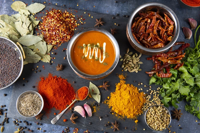 Top down photo of Indian curry with spice ingredients spread around
